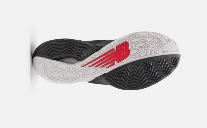 View of the white, black, and red outsole of a New Balance basketball shoe.